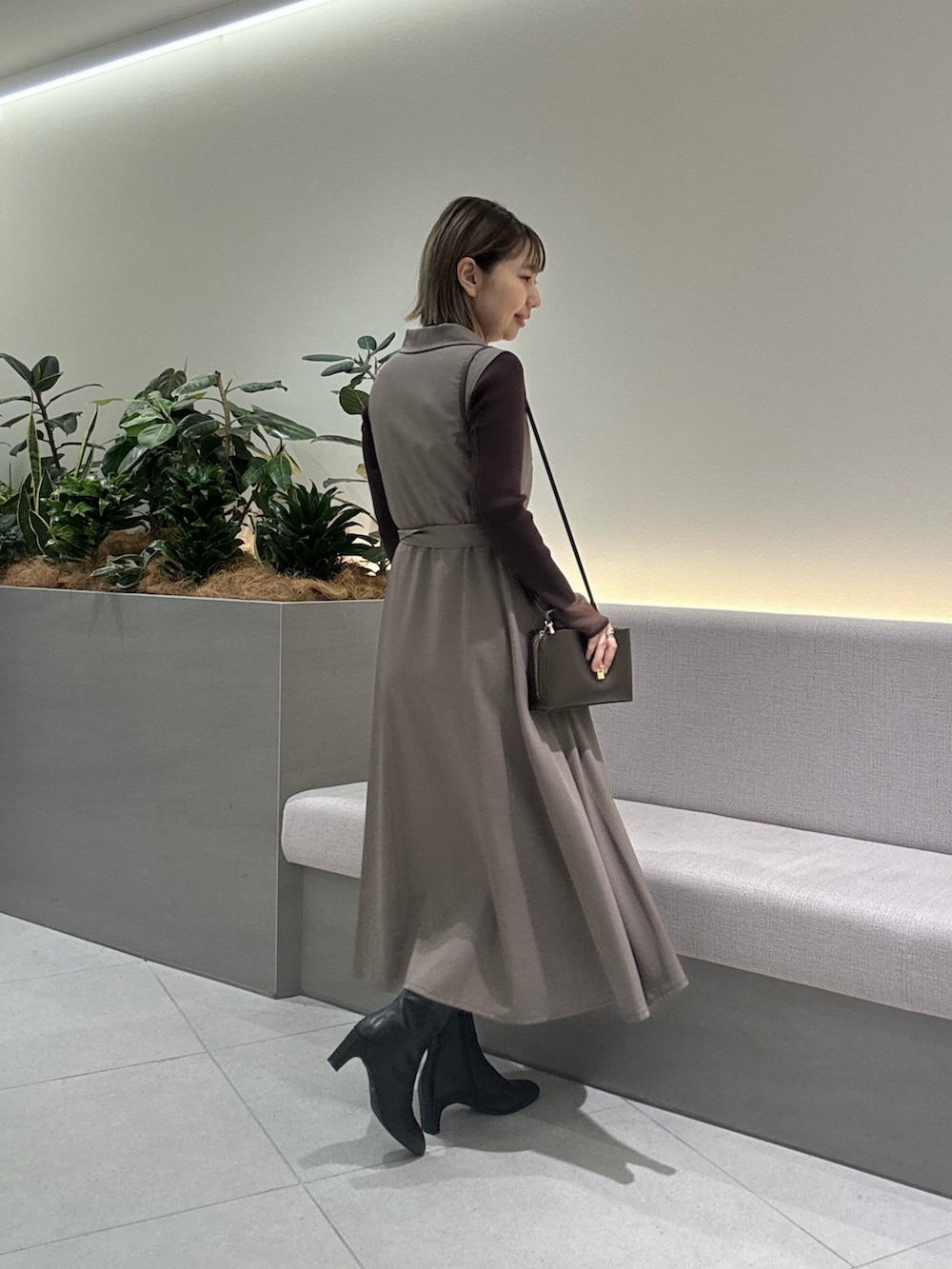 ブラウン系のニット/セーター、ブラウン系のワンピース、ブラック系のショルダーバッグを着用したレディースの秋コーディネートの3枚目の写真