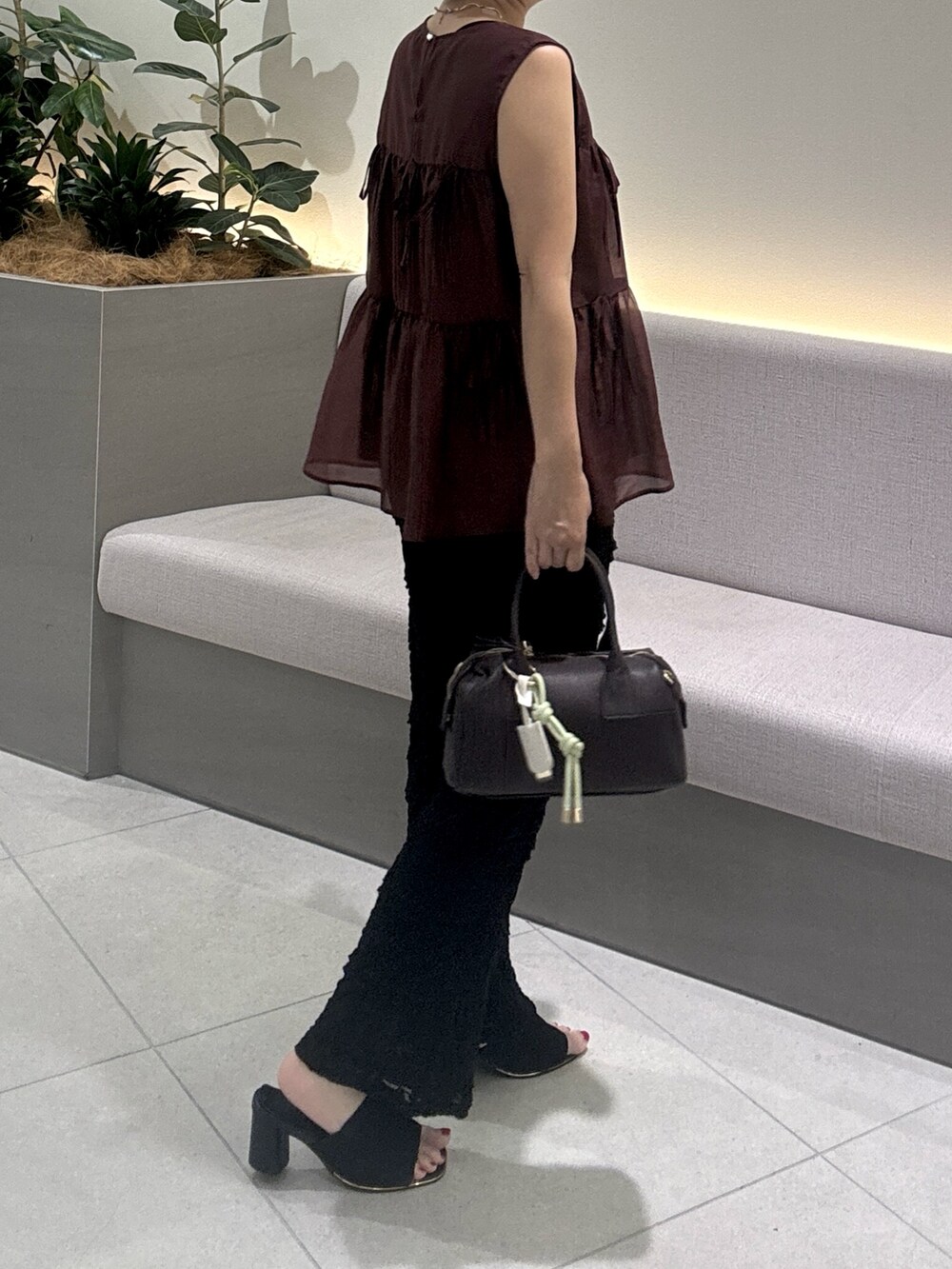 レッド系のシャツ/ブラウス、ブラック系のその他パンツ、ブラウン系のボストンバッグを着用したレディースの夏コーディネートの4枚目の写真