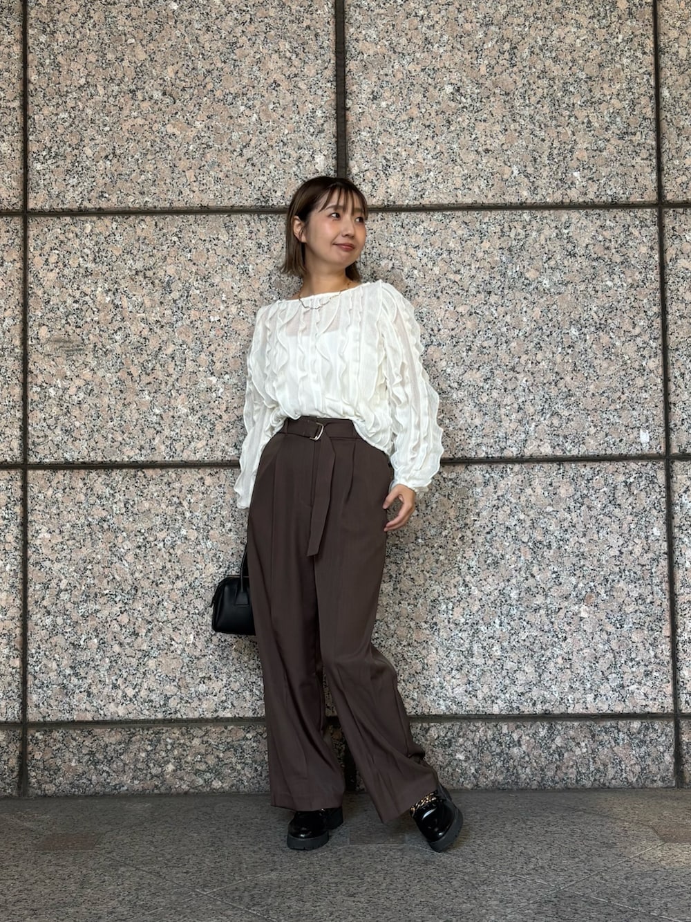 ブラウン系のその他パンツ、ホワイト系のTシャツ/カットソー、ブラック系のボストンバッグを着用したレディースの秋コーディネートの2枚目の写真
