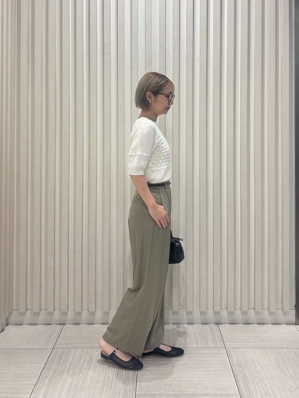 グリーン系のその他パンツ、ホワイト系のニット/セーター、ブラック系のボストンバッグを着用したレディースの夏コーディネートの4枚目の写真