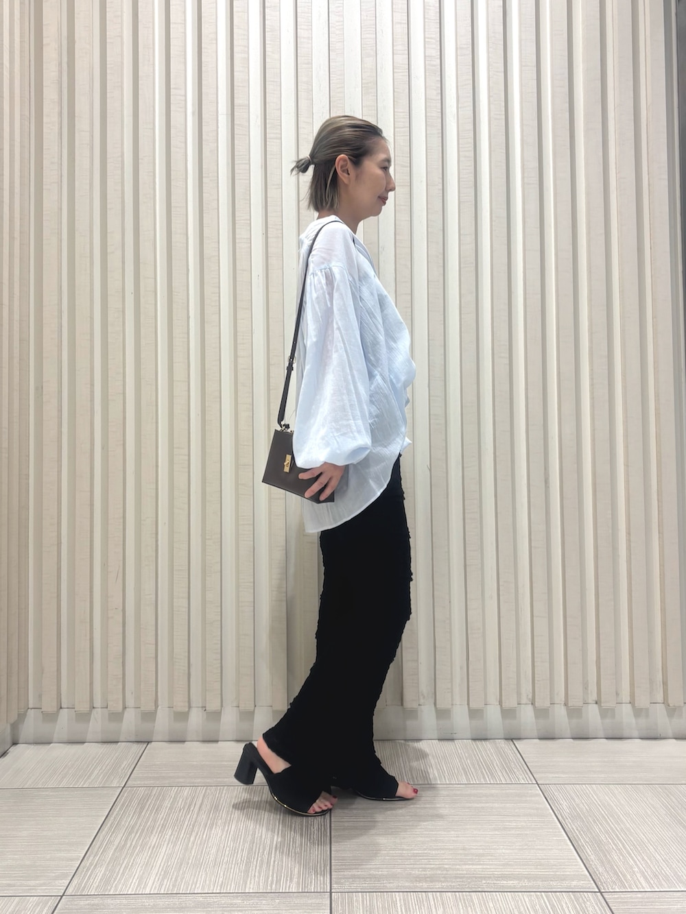 ブラック系のその他パンツ、ブルー系のシャツ/ブラウス、ブラウン系のショルダーバッグを着用したレディースの夏コーディネートの2枚目の写真