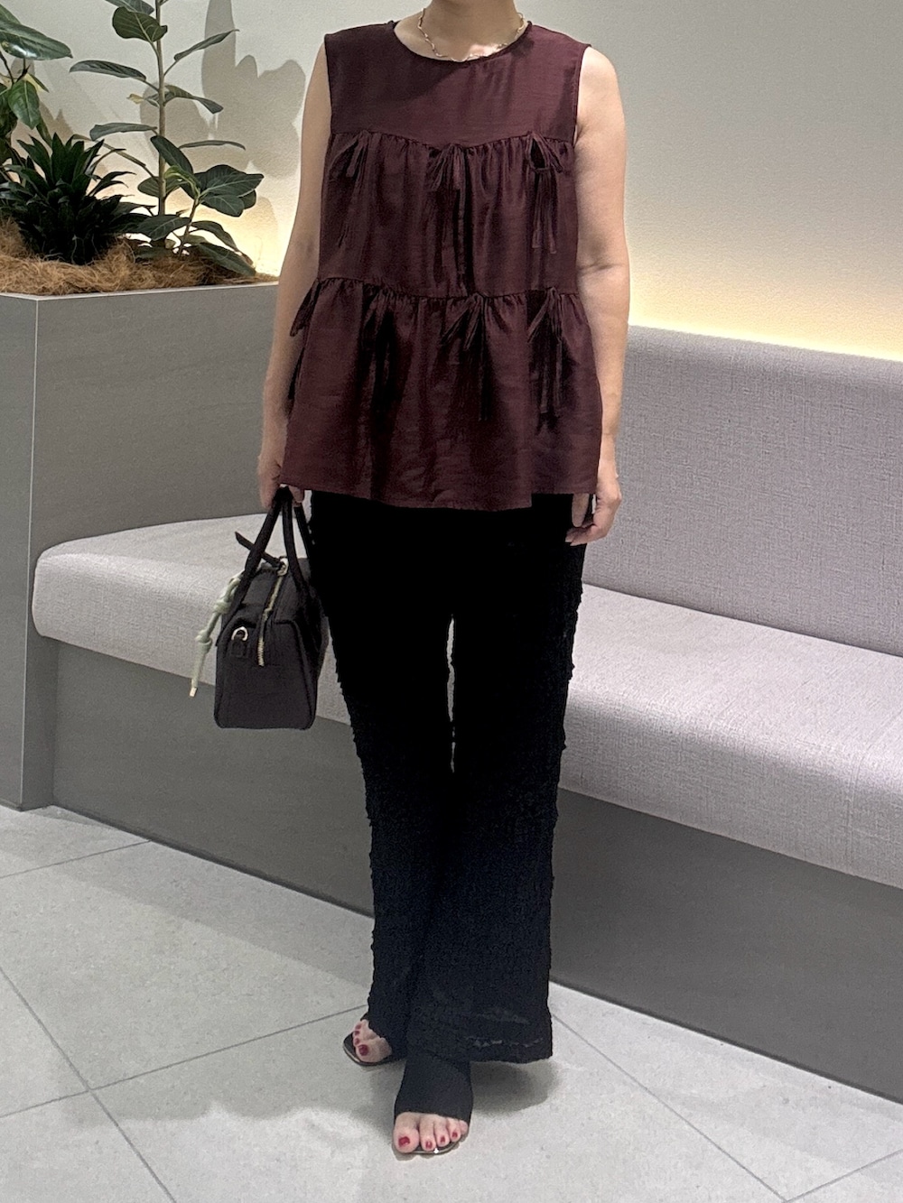 レッド系のシャツ/ブラウス、ブラック系のその他パンツ、ブラウン系のボストンバッグを着用したレディースの夏コーディネートの3枚目の写真