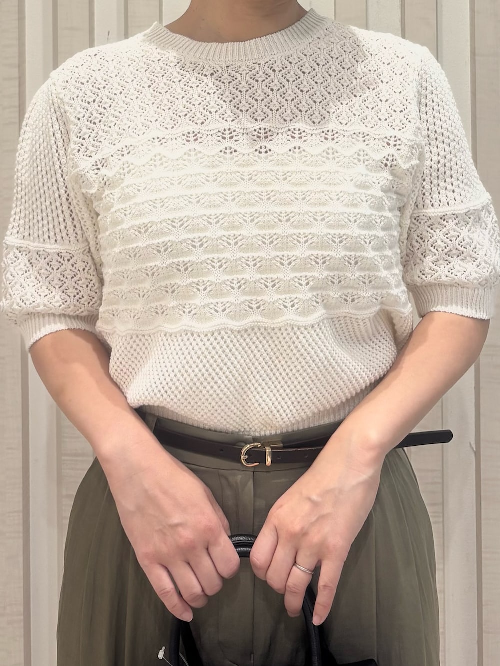 グリーン系のその他パンツ、ホワイト系のニット/セーター、ブラック系のボストンバッグを着用したレディースの夏コーディネートの6枚目の写真