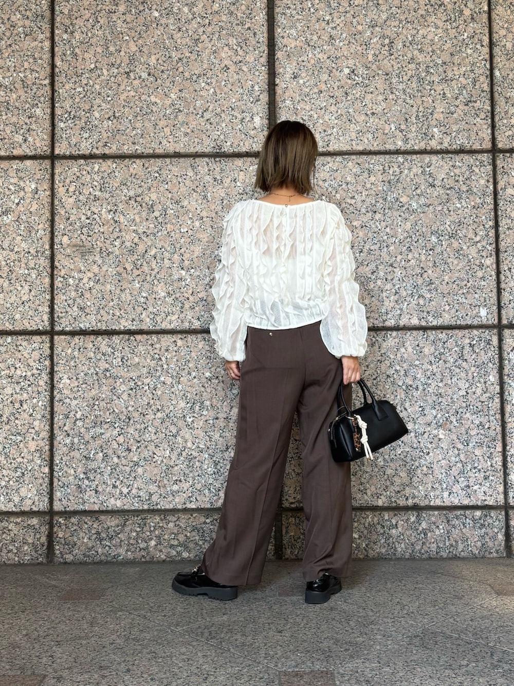 ブラウン系のその他パンツ、ホワイト系のTシャツ/カットソー、ブラック系のボストンバッグを着用したレディースの秋コーディネートの5枚目の写真