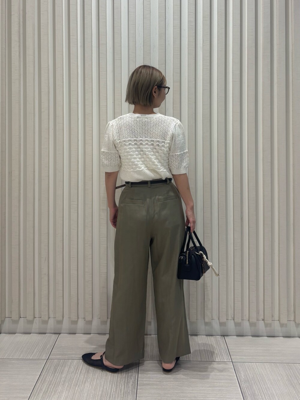 グリーン系のその他パンツ、ホワイト系のニット/セーター、ブラック系のボストンバッグを着用したレディースの夏コーディネートの5枚目の写真