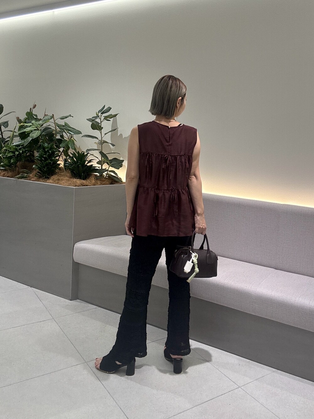 レッド系のシャツ/ブラウス、ブラック系のその他パンツ、ブラウン系のボストンバッグを着用したレディースの夏コーディネートの5枚目の写真