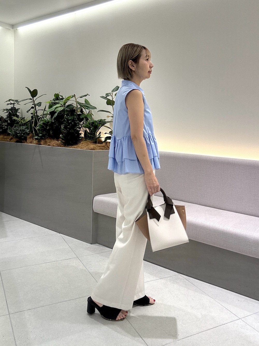 ブルー系のシャツ/ブラウス、ベージュ系のその他パンツ、ホワイト系のトートバッグを着用したレディースの夏コーディネートの3枚目の写真