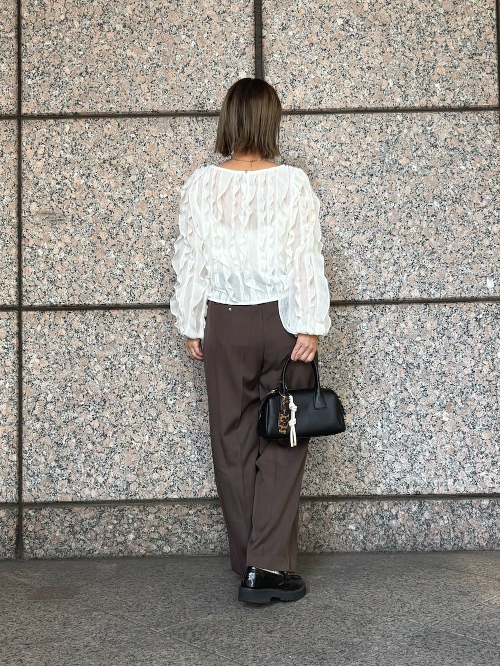 ブラウン系のその他パンツ、ホワイト系のTシャツ/カットソー、ブラック系のボストンバッグを着用したレディースの秋コーディネートの4枚目の写真