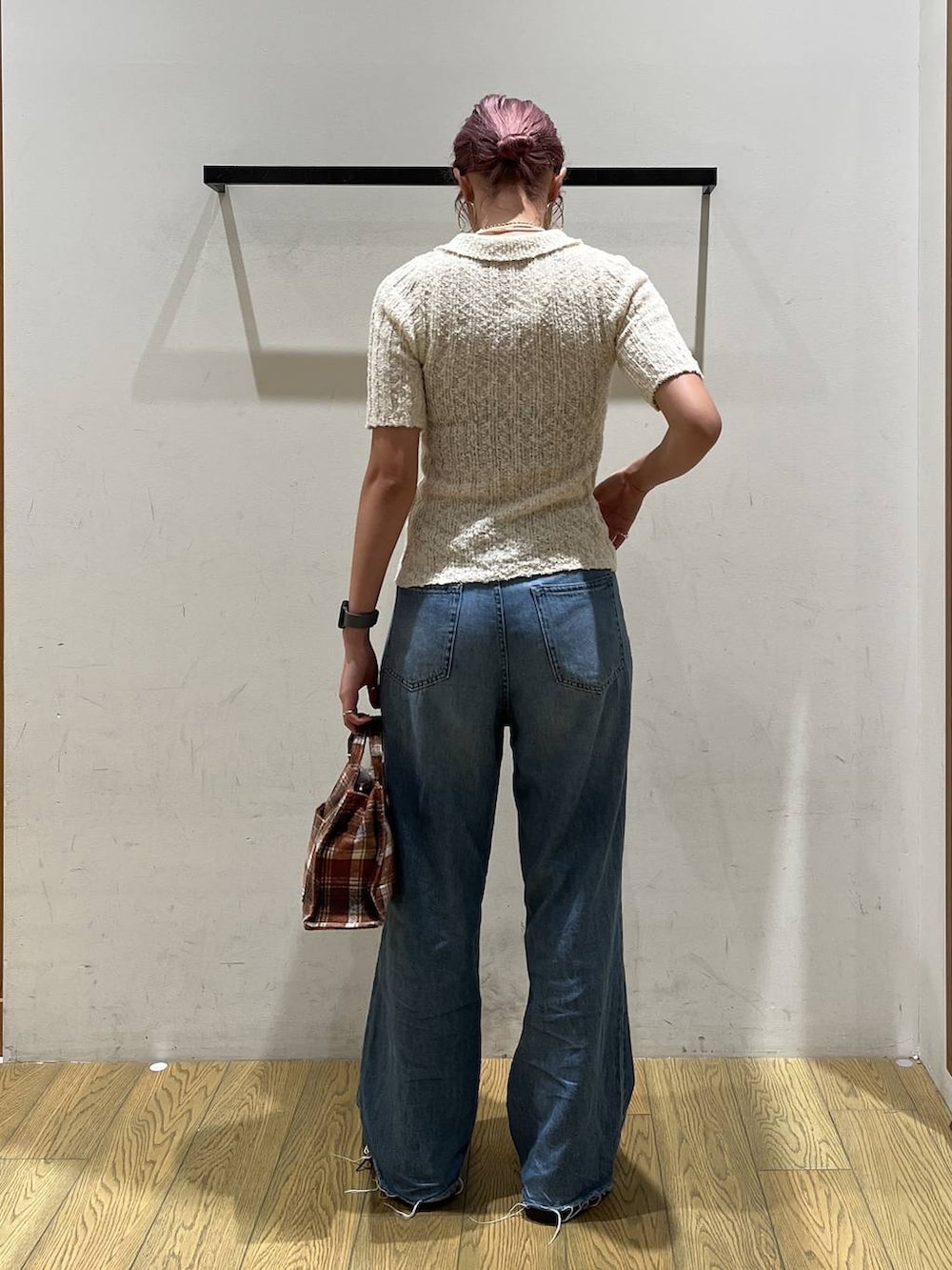 ブルー系のデニムパンツ、オレンジ系のトートバッグ、ホワイト系のニット/セーターを着用したレディースの夏コーディネートの4枚目の写真