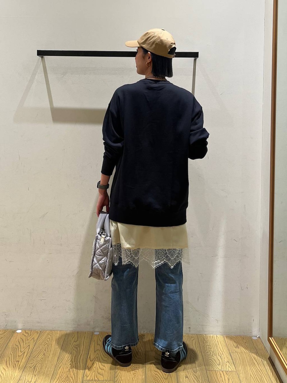 グレー系のショルダーバッグ、ブルー系のスウェット、ブルー系のデニムパンツを着用したレディースの冬コーディネートの4枚目の写真