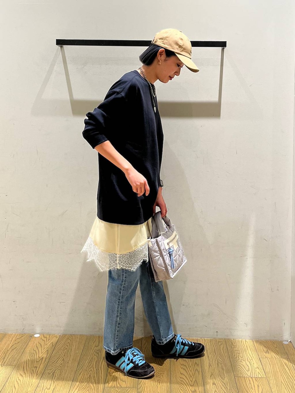 グレー系のショルダーバッグ、ブルー系のスウェット、ブルー系のデニムパンツを着用したレディースの冬コーディネートの3枚目の写真