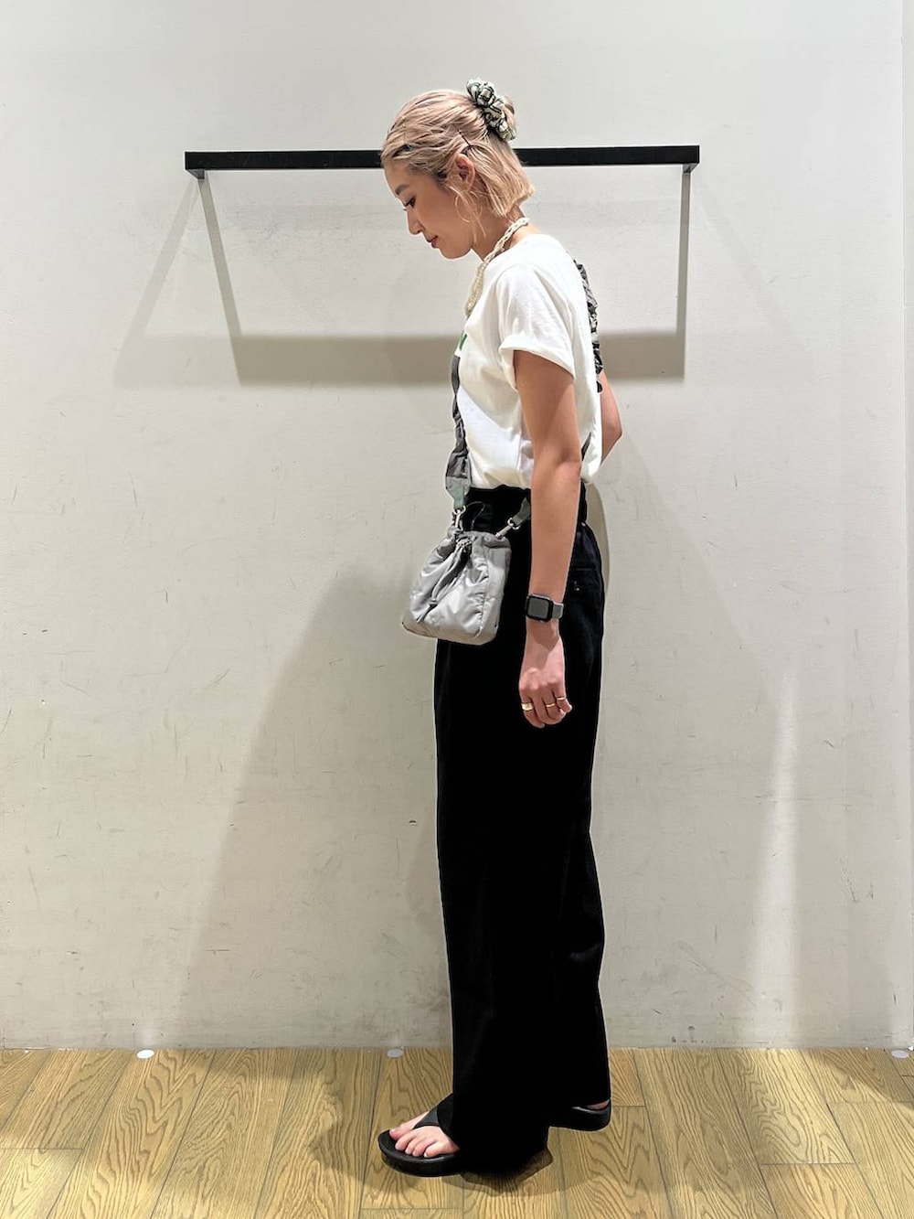 ブラック系のチノパンツ、グリーン系のショルダーバッグ、グリーン系のTシャツ/カットソーを着用したレディースの夏コーディネートの3枚目の写真