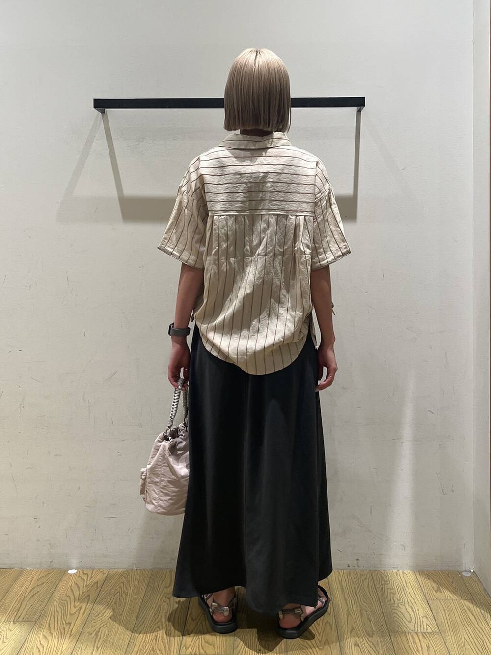 ベージュ系のショルダーバッグ、ベージュ系のシャツ/ブラウス、グレー系のスカートを着用したレディースの夏コーディネートの4枚目の写真