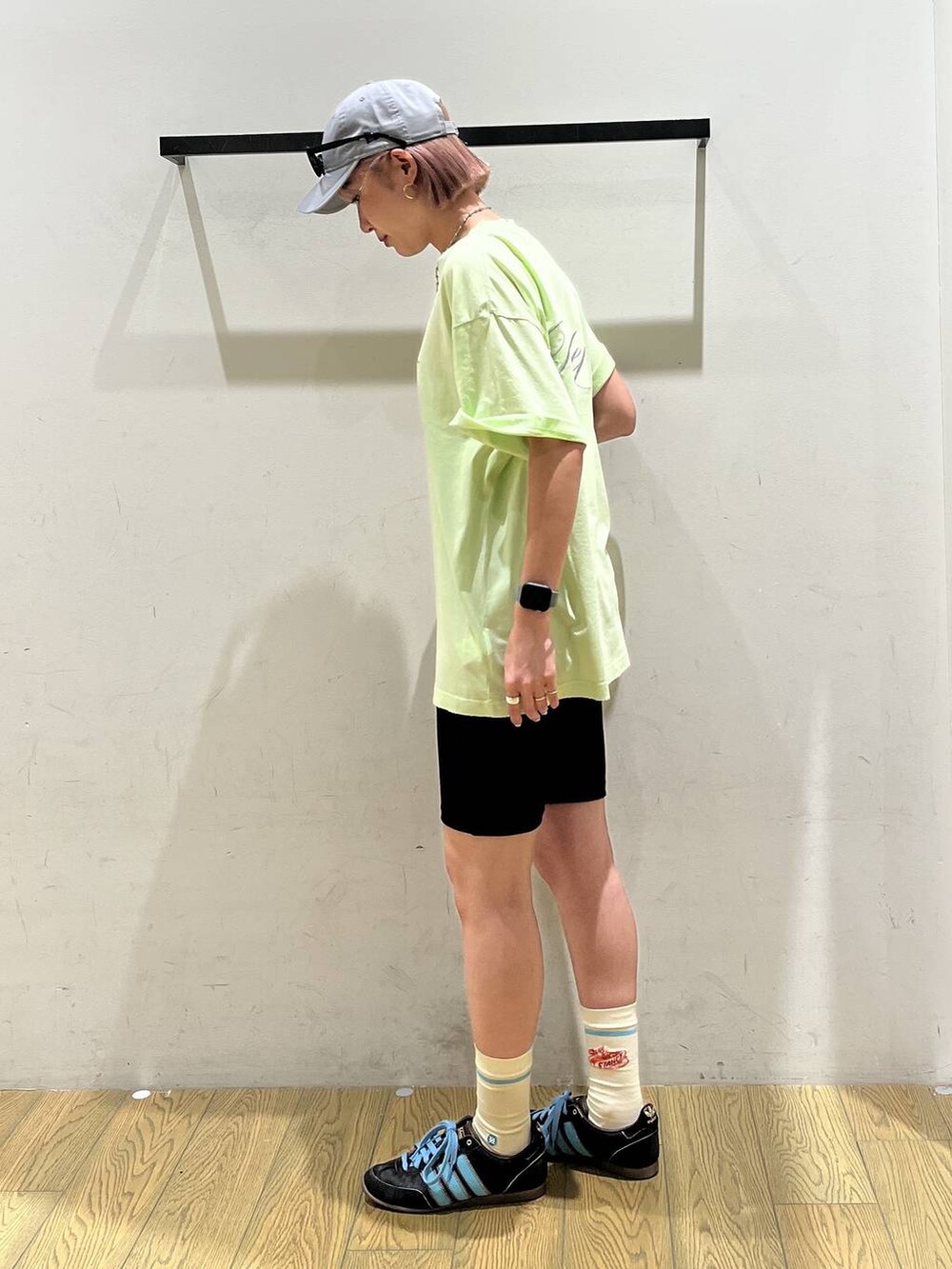 グリーン系のTシャツ/カットソー、グレー系のキャップ、ブラック系のサングラスを着用したレディースの夏コーディネートの2枚目の写真