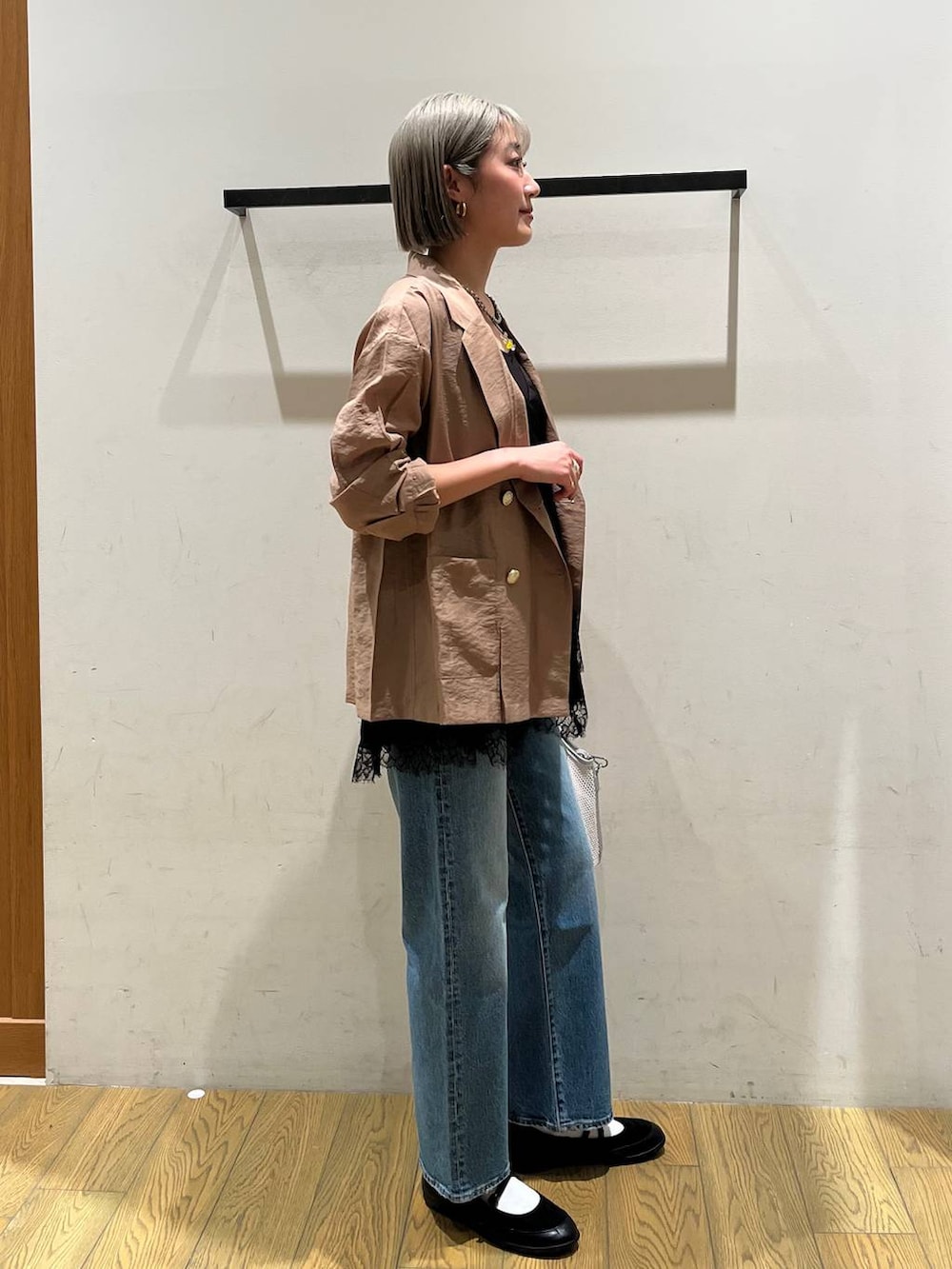 ブルー系のデニムパンツ、ブラック系のバレエシューズ、グレー系のショルダーバッグを着用したレディースの春コーディネートの3枚目の写真