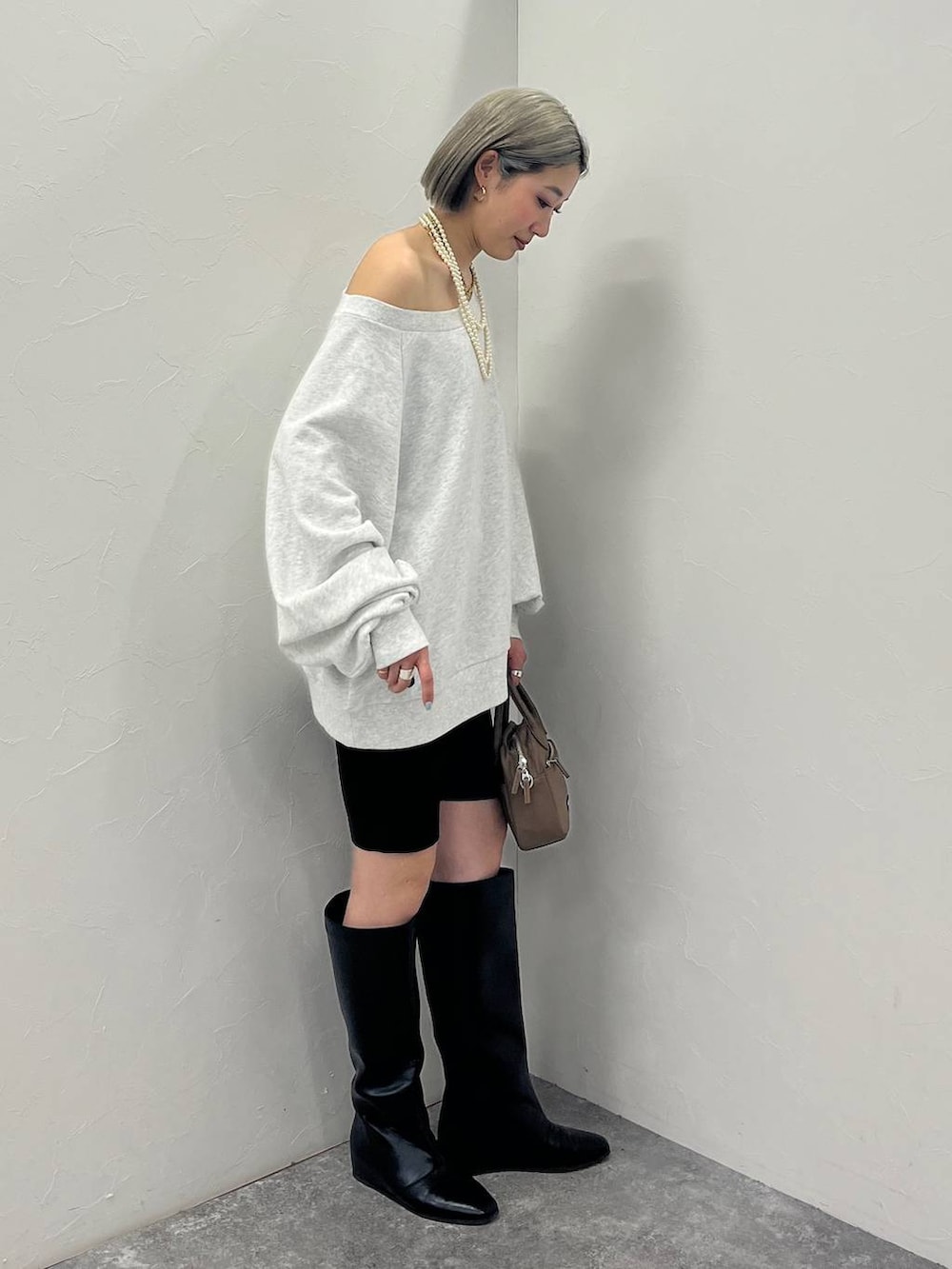 ブラック系のブーツ、ブラウン系のハンドバッグ、ブラック系のその他パンツを着用したレディースの冬コーディネートの3枚目の写真