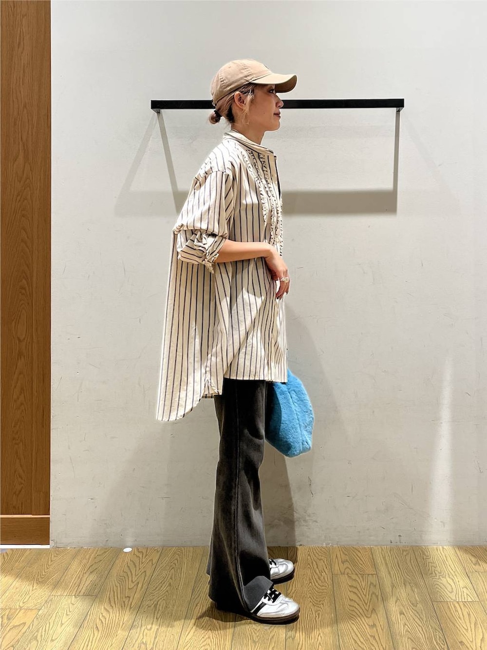 ベージュ系のチュニック、グレー系のその他パンツ、ブルー系のハンドバッグを着用したレディースの秋コーディネートの2枚目の写真