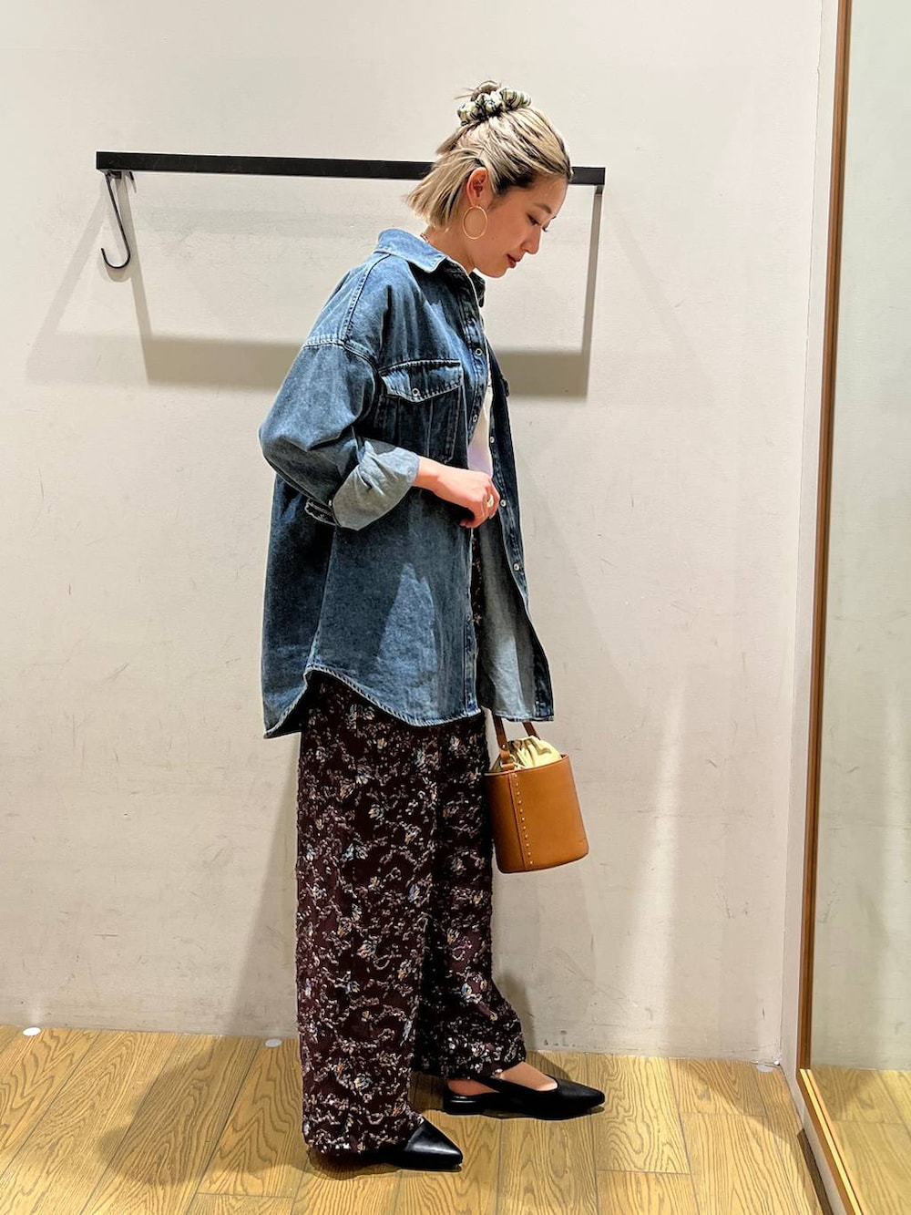 イエロー系のハンドバッグ、ブラック系のパンプス、ホワイト系のTシャツ/カットソーを着用したレディースの春コーディネートの3枚目の写真