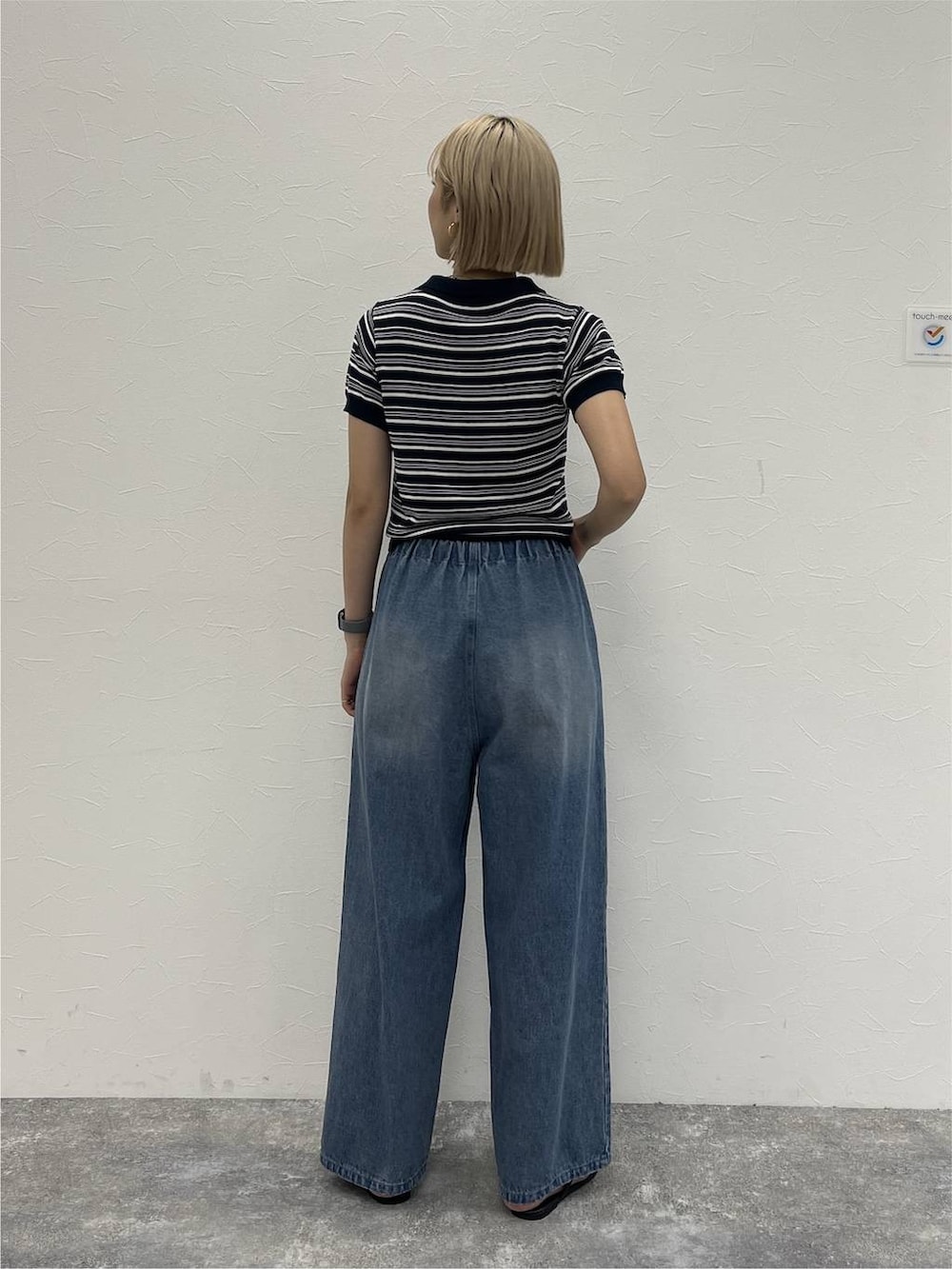 ブルー系のデニムパンツ、ブルー系のポロシャツを着用したレディースの夏コーディネートの4枚目の写真