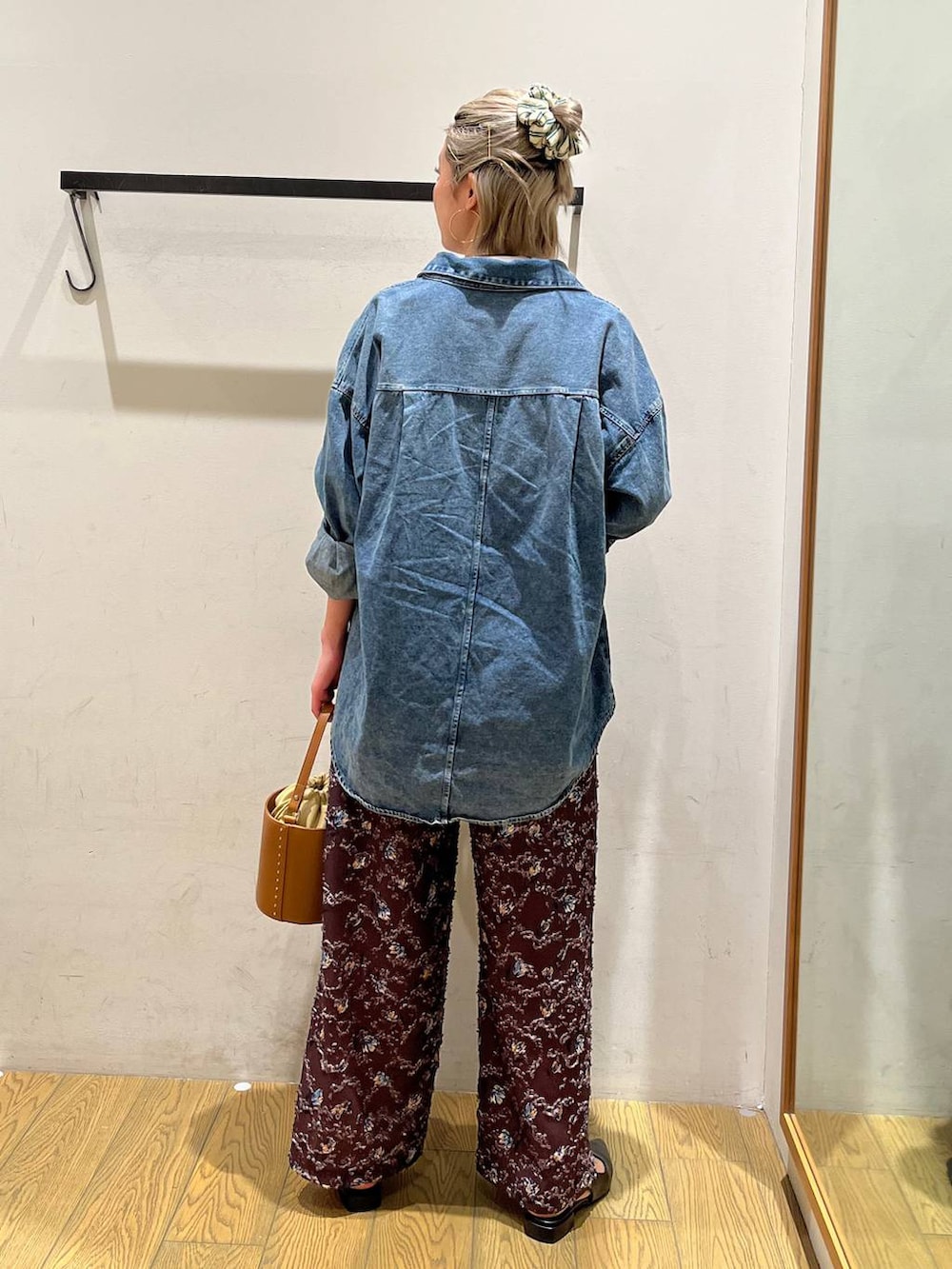 イエロー系のハンドバッグ、ブラック系のパンプス、ホワイト系のTシャツ/カットソーを着用したレディースの春コーディネートの4枚目の写真