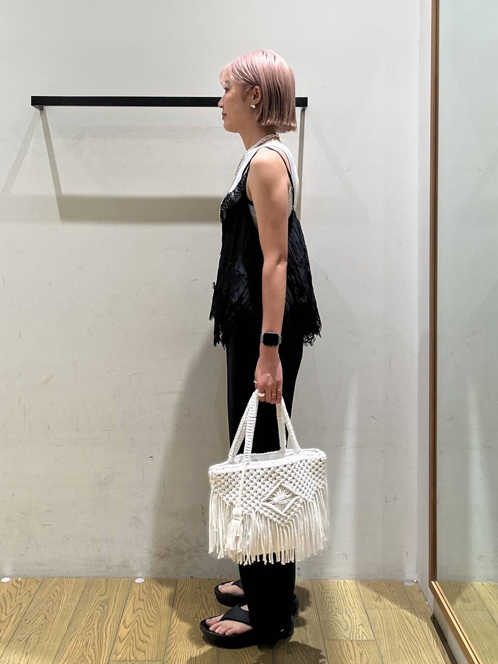 ベージュ系のトートバッグ、ブラック系のサンダル、グレー系のタンクトップを着用したレディースの夏コーディネートの3枚目の写真