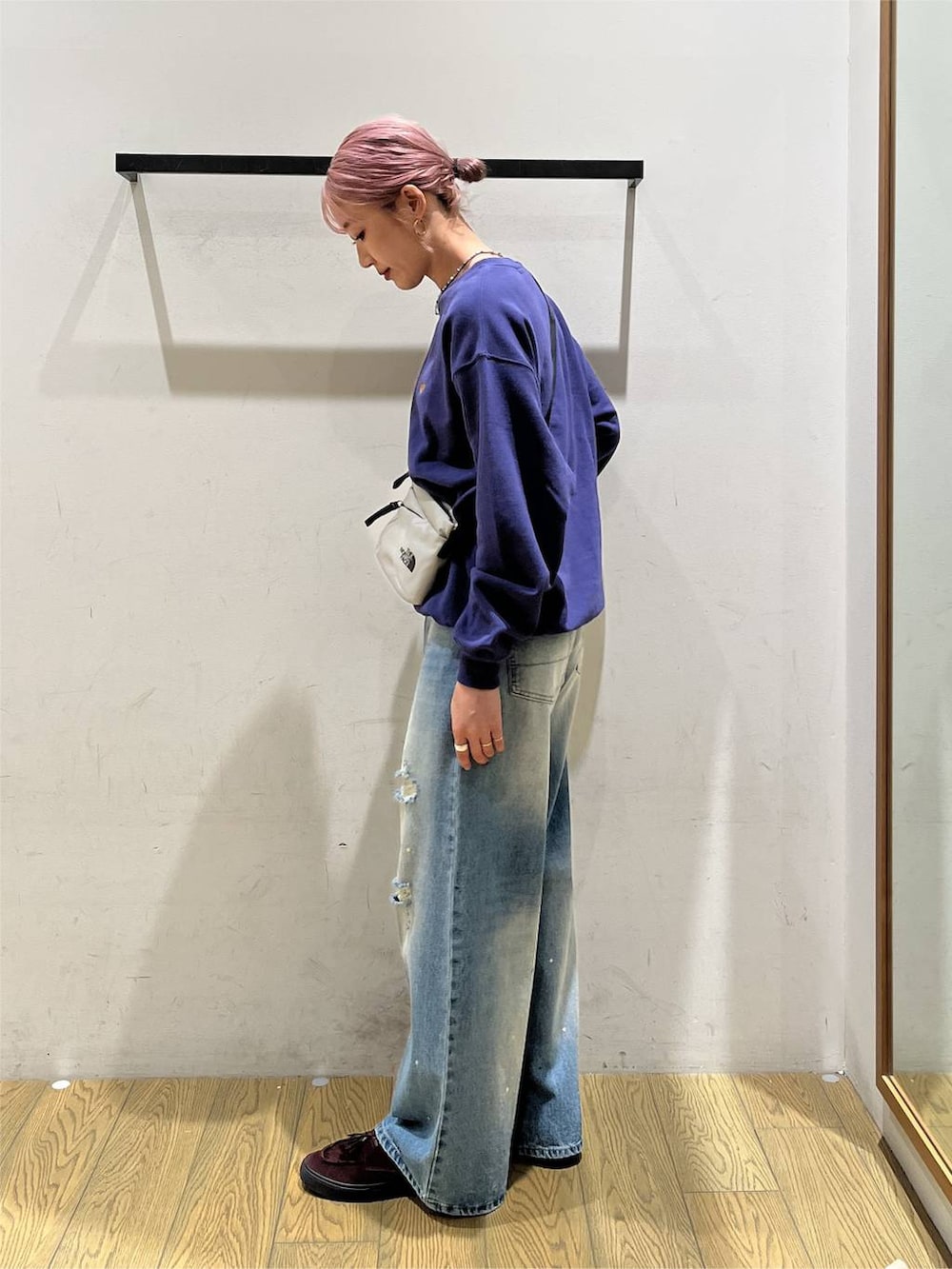 ブルー系のデニムパンツ、グレー系のショルダーバッグ、ブルー系のスウェットを着用したレディースの秋コーディネートの3枚目の写真