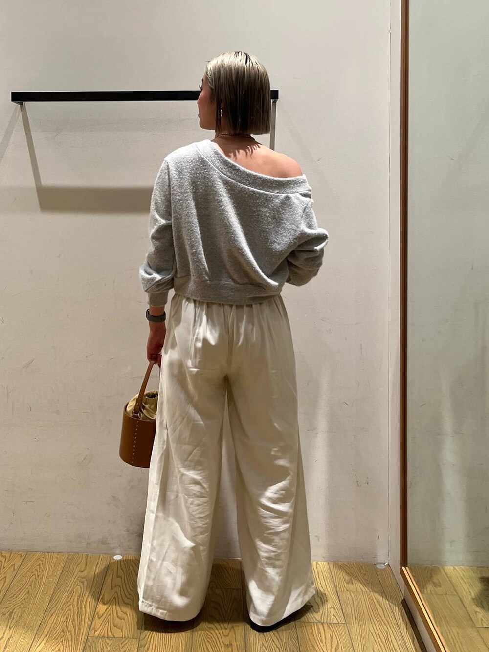 イエロー系のハンドバッグ、グレー系のTシャツ/カットソー、ベージュ系のその他パンツを着用したレディースの冬コーディネートの4枚目の写真