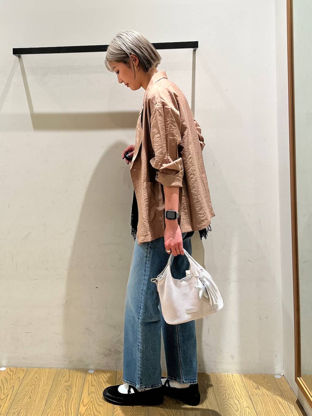 ブルー系のデニムパンツ、ブラック系のバレエシューズ、グレー系のショルダーバッグを着用したレディースの春コーディネートの2枚目の写真