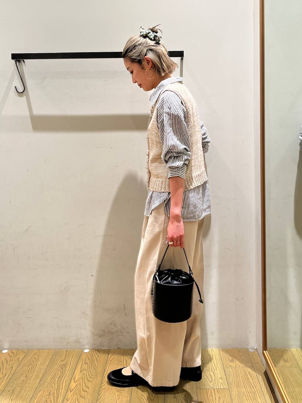 ブルー系のシャツ/ブラウス、ブラック系のハンドバッグ、ブラック系のバレエシューズを着用したレディースの春コーディネートの3枚目の写真