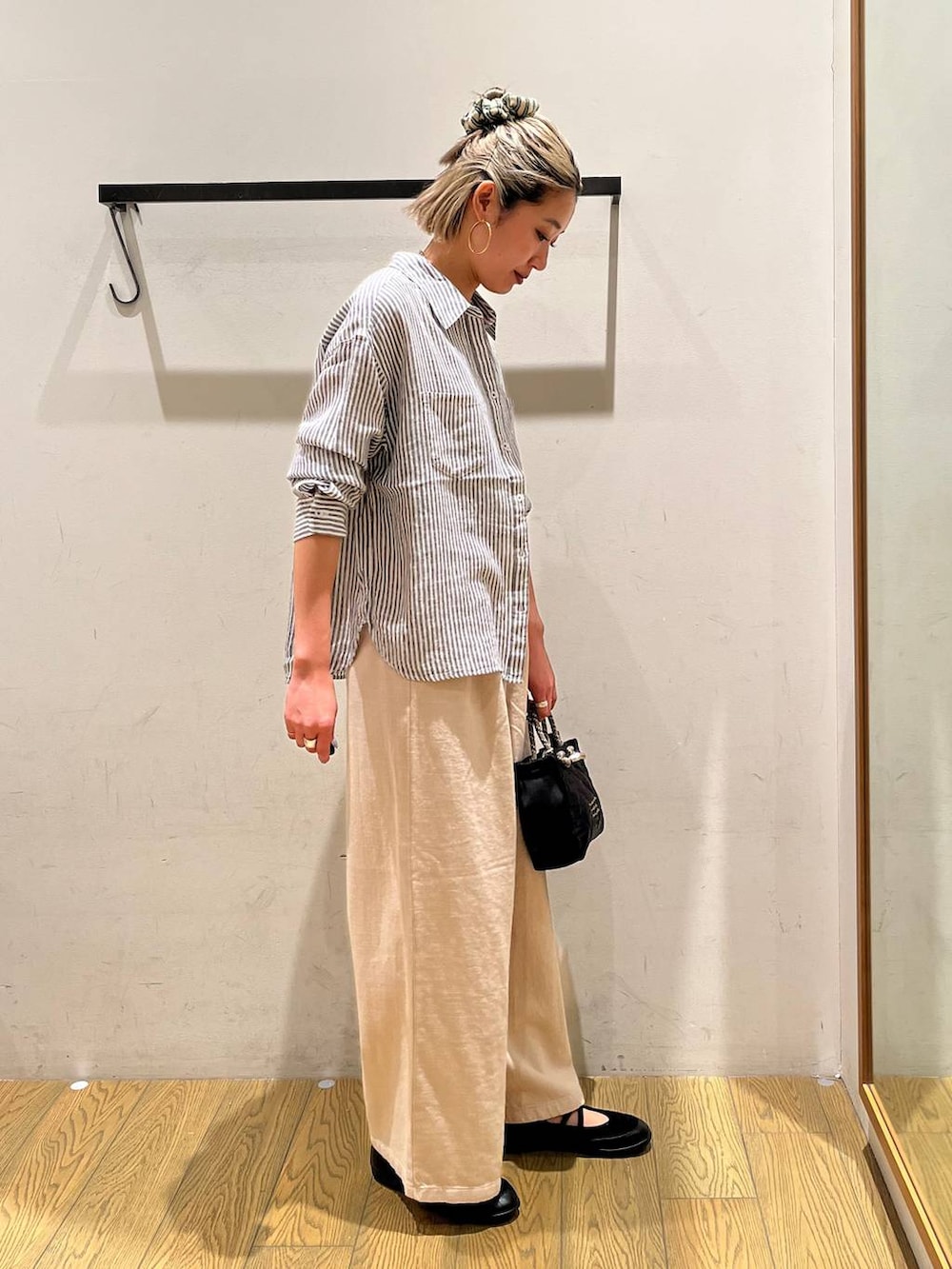 ブルー系のシャツ/ブラウス、ブラック系のショルダーバッグ、ブラック系のバレエシューズを着用したレディースの春コーディネートの2枚目の写真