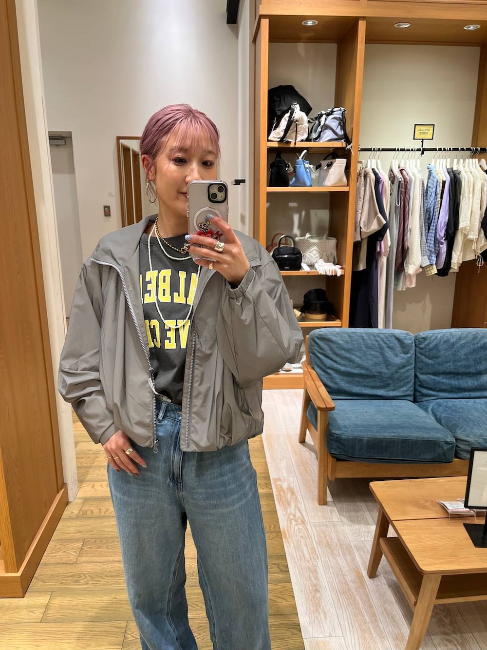 ブルー系のデニムパンツ、グレー系のTシャツ/カットソー、シルバー系のブルゾンを着用したレディースの夏コーディネートの5枚目の写真