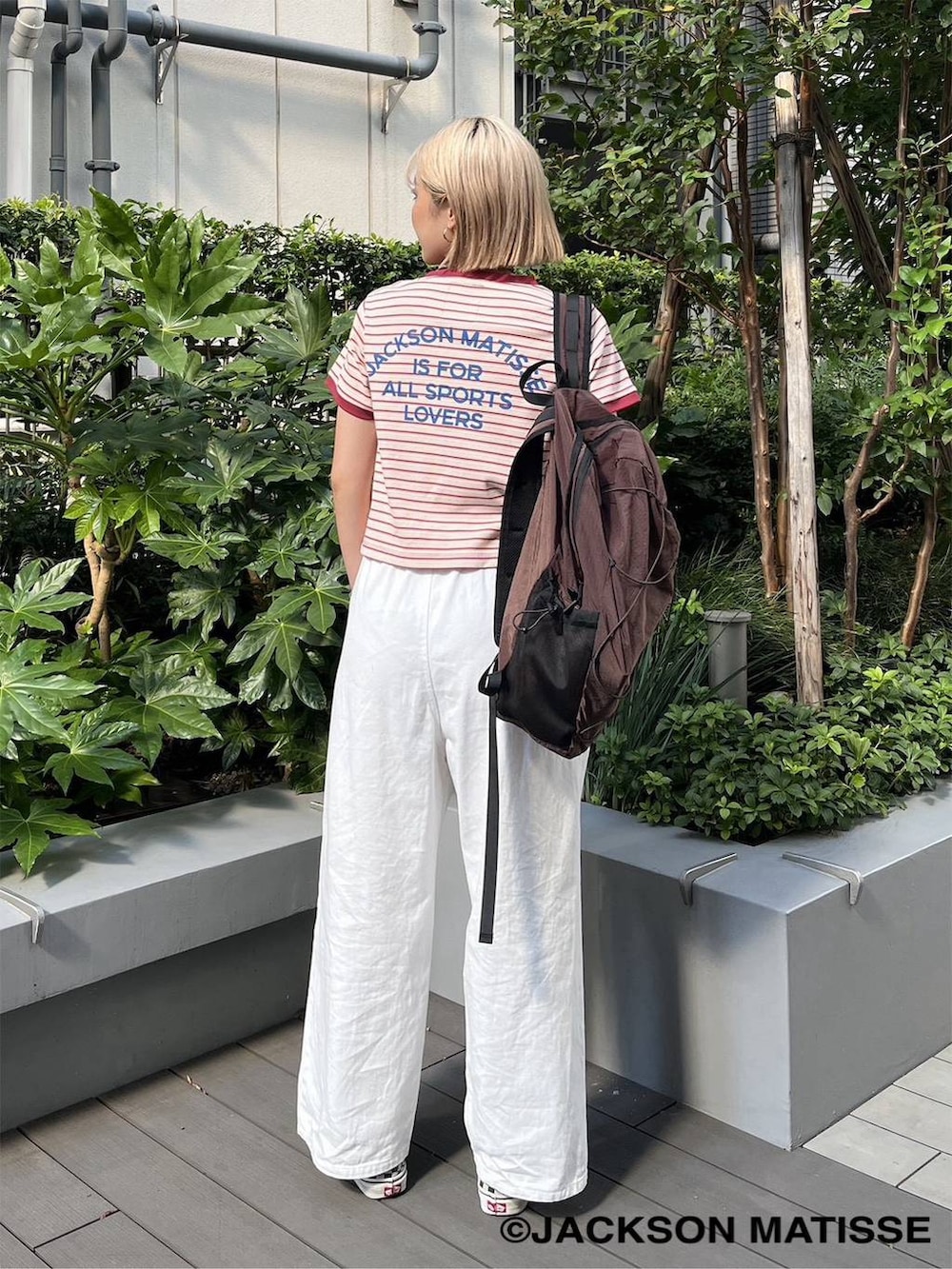 ブラウン系のバックパック/リュック、ピンク系のTシャツ/カットソー、ホワイト系のデニムパンツを着用したレディースの夏コーディネートの2枚目の写真