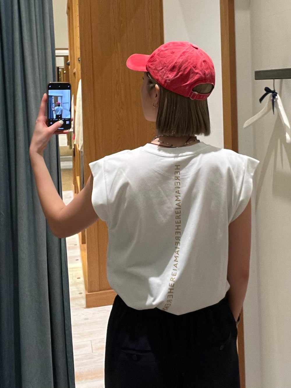 ブルー系のその他パンツ、ホワイト系のTシャツ/カットソー、レッド系のキャップを着用したレディースの春コーディネートの2枚目の写真