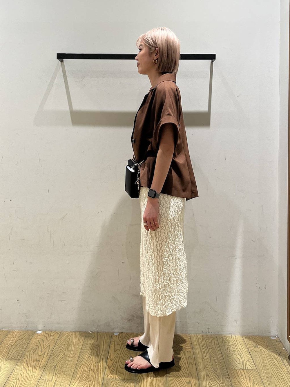 ホワイト系のその他パンツ、ブラック系のサンダル、ブラウン系のテーラードジャケットを着用したレディースの夏コーディネートの2枚目の写真