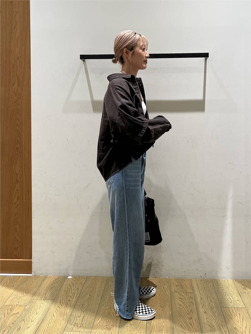 ブルー系のデニムパンツ、ブラウン系のシャツ/ブラウス、ブラック系のトートバッグを着用したレディースの夏コーディネートの2枚目の写真