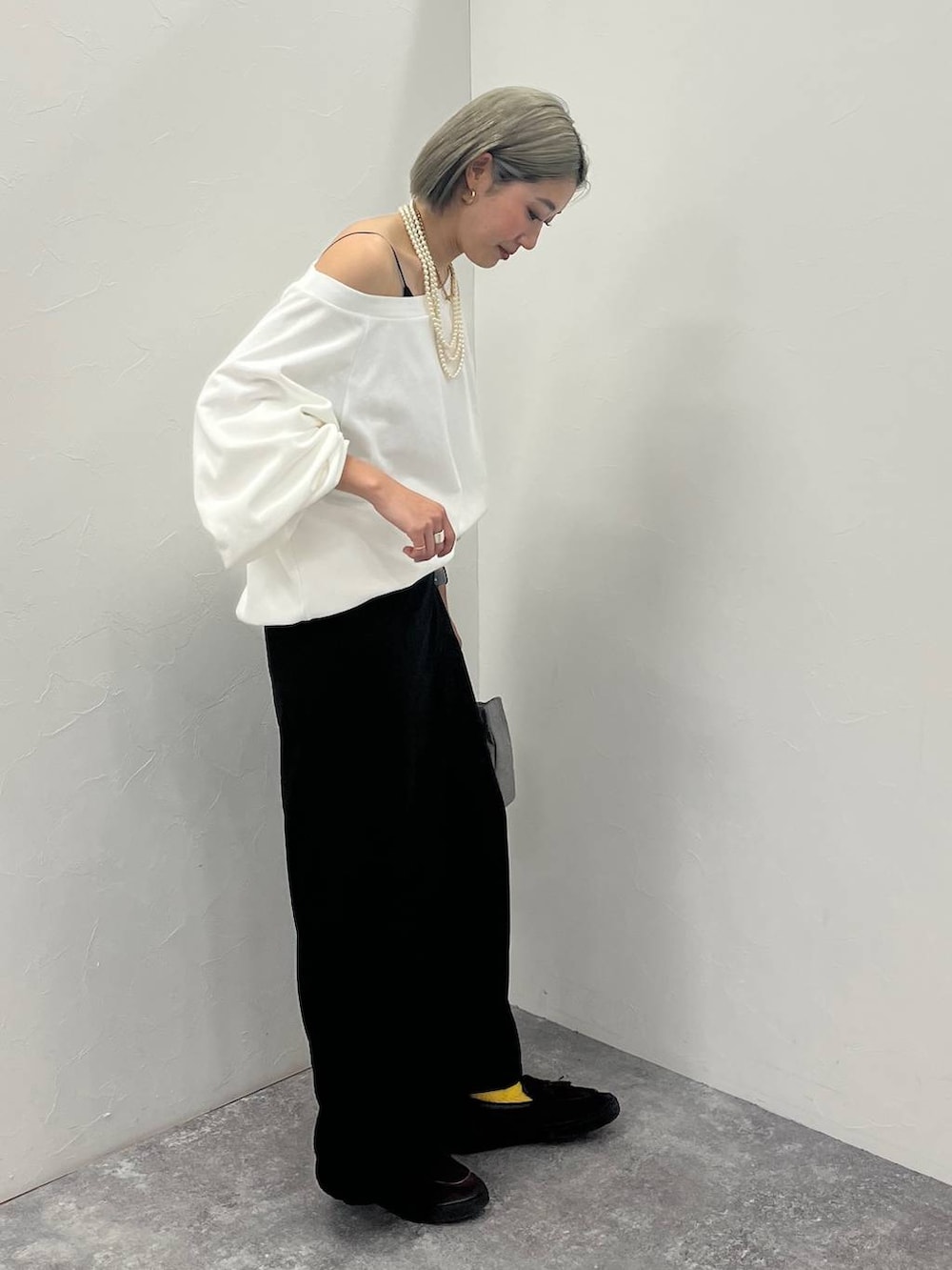 ホワイト系のスウェット、ブラック系のショルダーバッグを着用したレディースの冬コーディネートの3枚目の写真