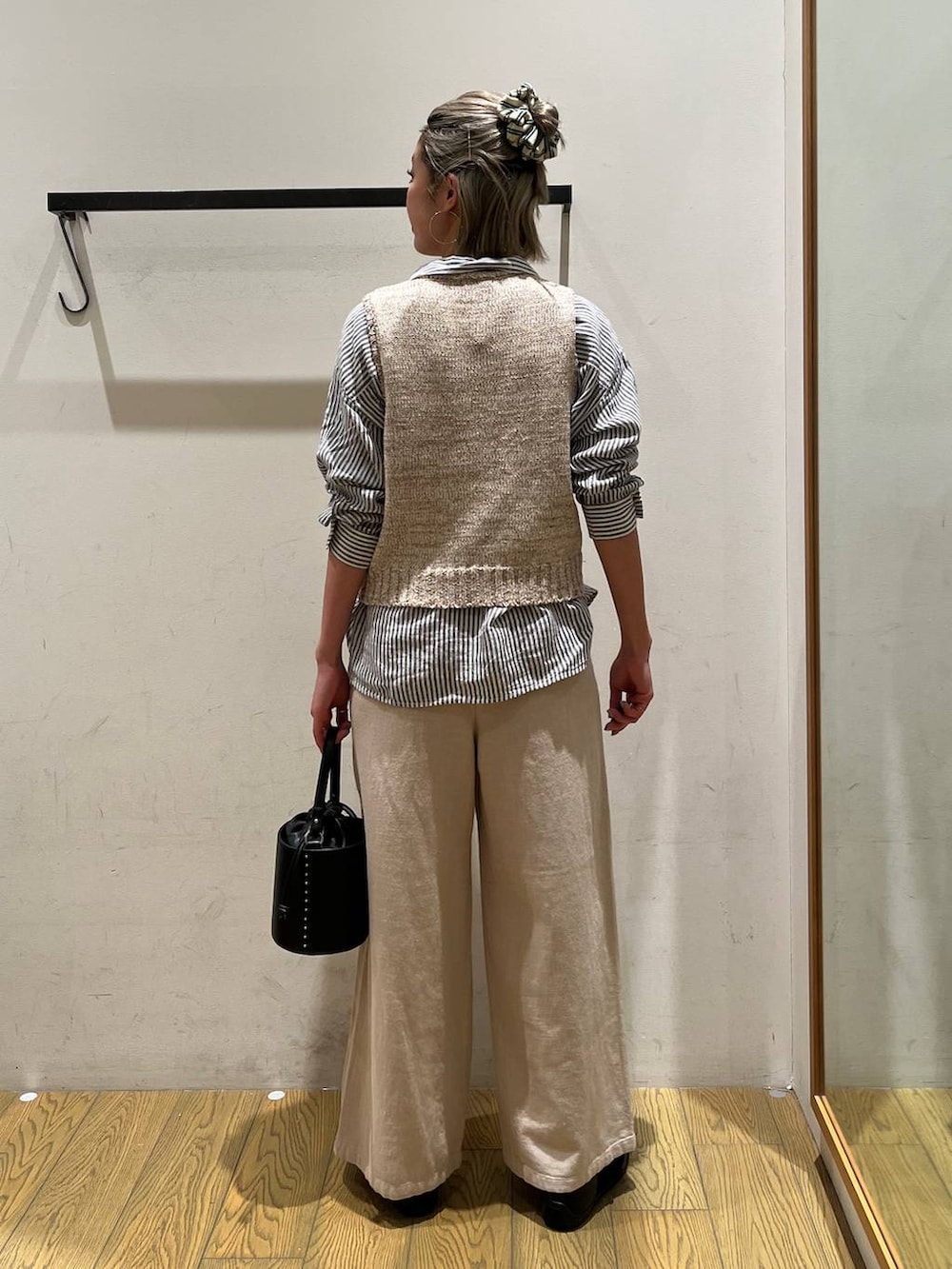 ブルー系のシャツ/ブラウス、ブラック系のハンドバッグ、ブラック系のバレエシューズを着用したレディースの春コーディネートの4枚目の写真