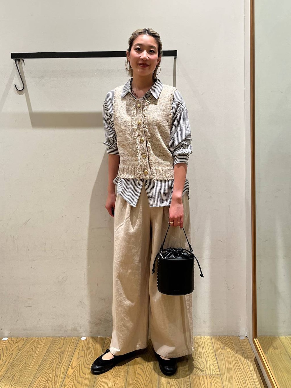 ブルー系のシャツ/ブラウス、ブラック系のハンドバッグ、ブラック系のバレエシューズを着用したレディースの春コーディネートの5枚目の写真