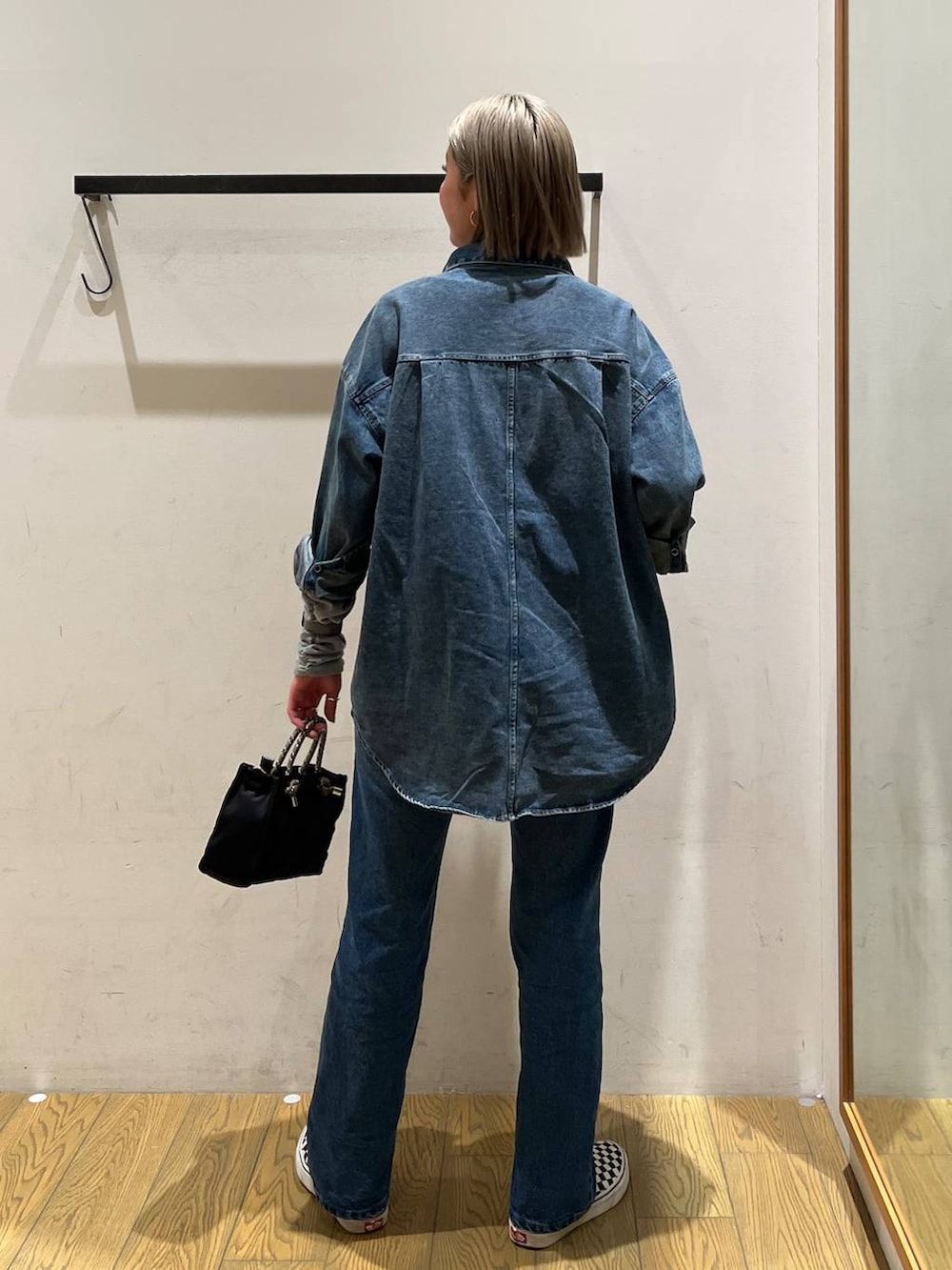 ブルー系のデニムパンツ、ブルー系のシャツ/ブラウス、ブラック系のショルダーバッグを着用したレディースの冬コーディネートの4枚目の写真