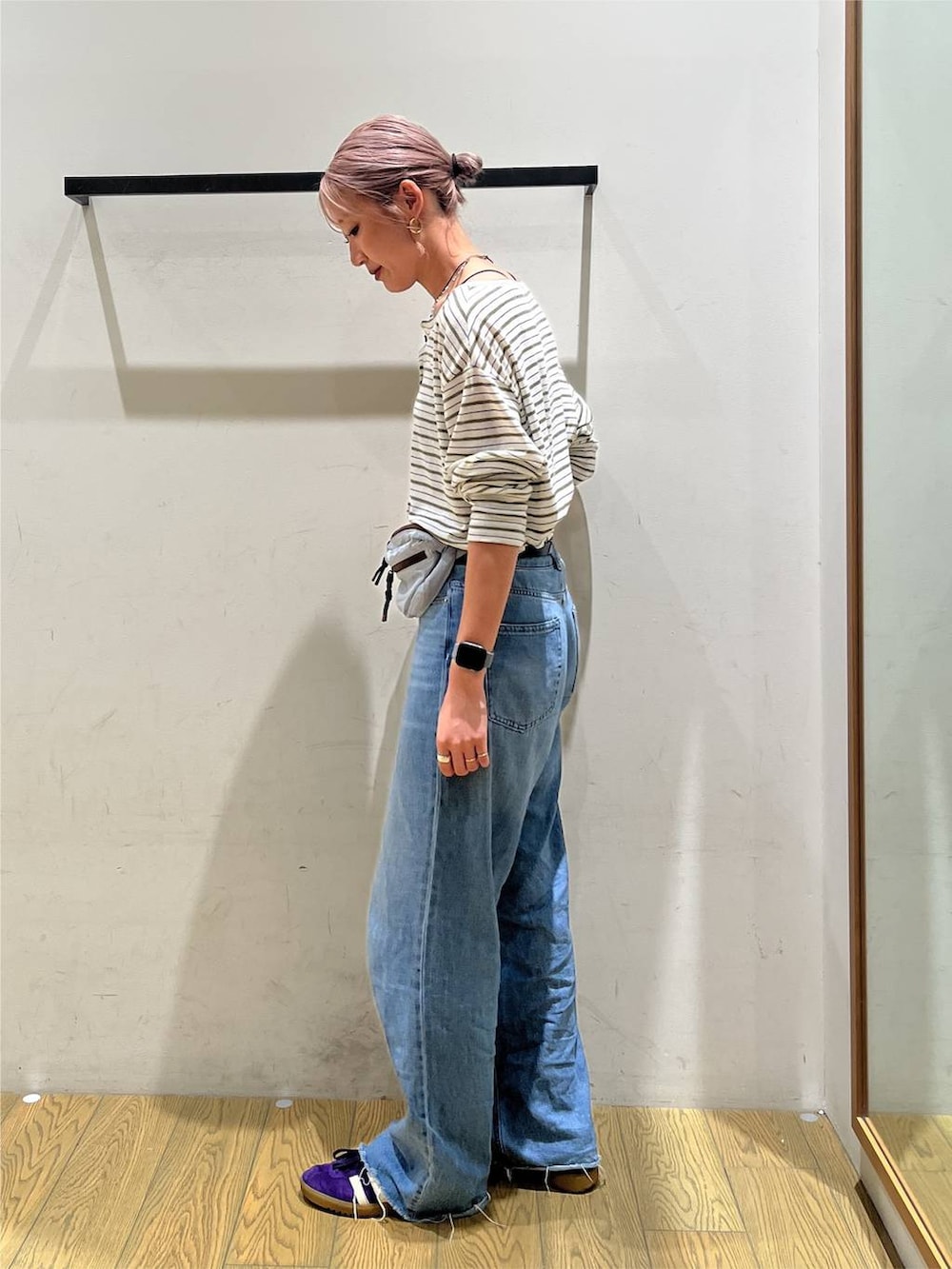 ブルー系のデニムパンツ、ブルー系のショルダーバッグ、ホワイト系のTシャツ/カットソーを着用したレディースの秋コーディネートの3枚目の写真
