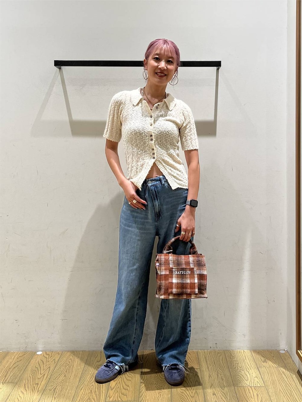 ブルー系のデニムパンツ、オレンジ系のトートバッグ、ホワイト系のニット/セーターを着用したレディースの夏コーディネートの5枚目の写真