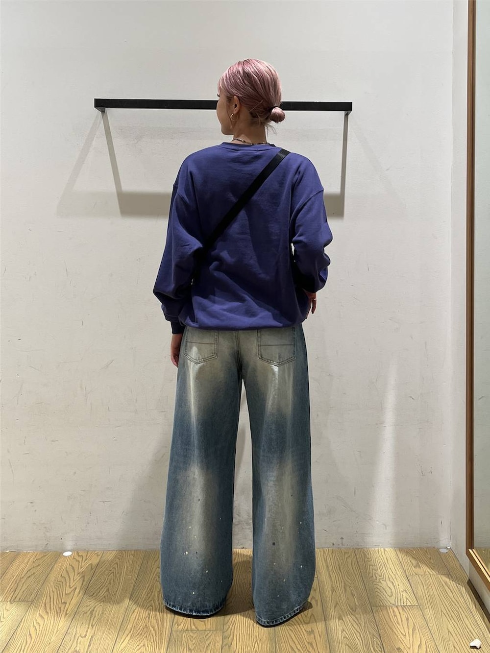 ブルー系のデニムパンツ、グレー系のショルダーバッグ、ブルー系のスウェットを着用したレディースの秋コーディネートの4枚目の写真