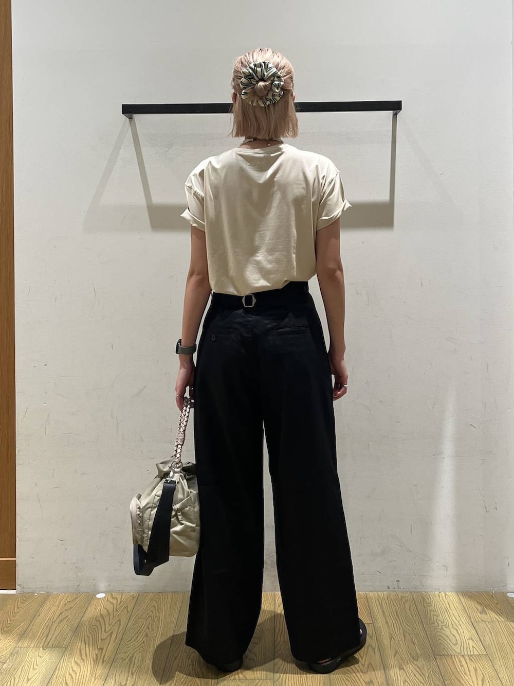 ベージュ系のTシャツ/カットソー、ブラック系のチノパンツ、ベージュ系のショルダーバッグを着用したレディースの夏コーディネートの4枚目の写真