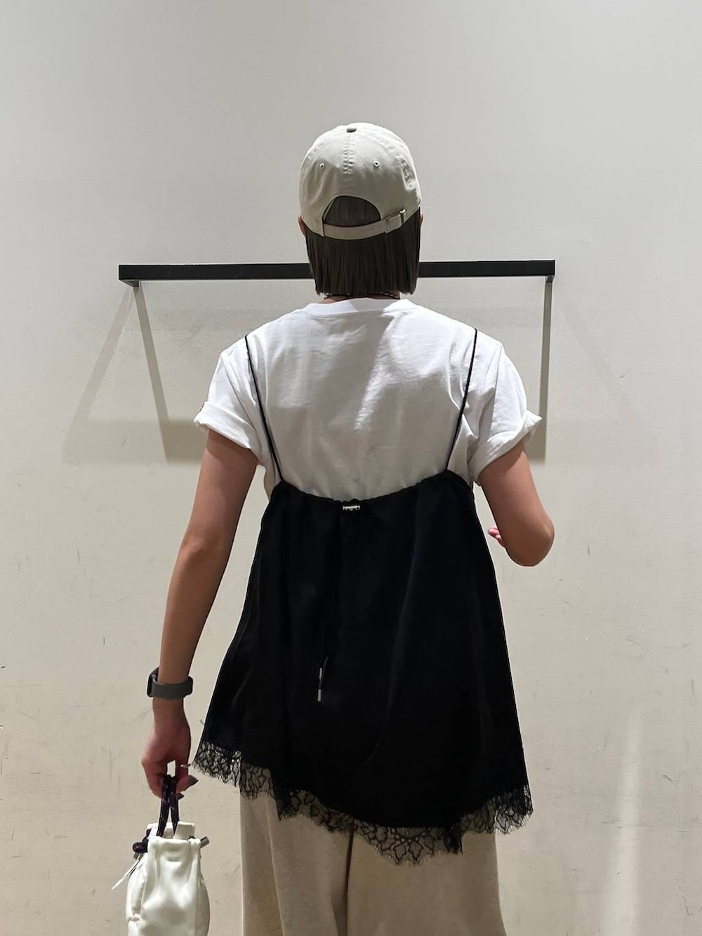 ブラック系のキャミソール、ホワイト系のTシャツ/カットソー、ホワイト系のショルダーバッグを着用したレディースの春コーディネートの5枚目の写真