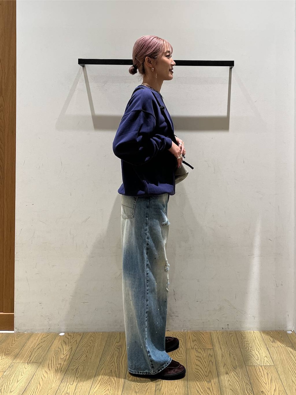 ブルー系のデニムパンツ、グレー系のショルダーバッグ、ブルー系のスウェットを着用したレディースの秋コーディネートの2枚目の写真