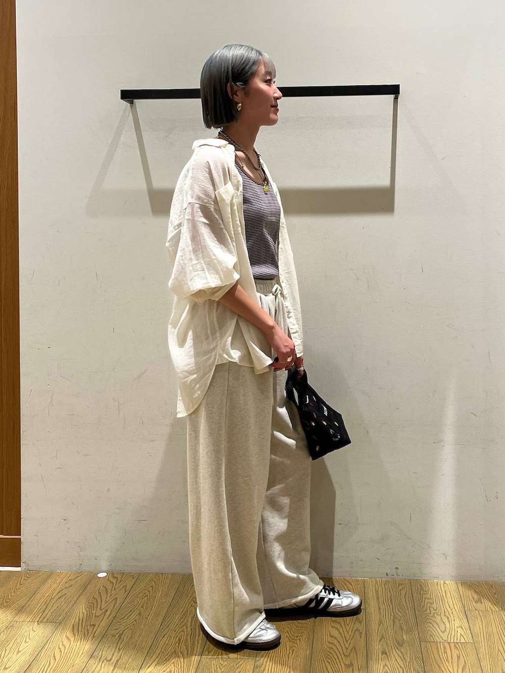 ホワイト系のシャツ/ブラウス、ブラウン系のタンクトップ、ブラック系のトートバッグを着用したレディースの春コーディネートの2枚目の写真