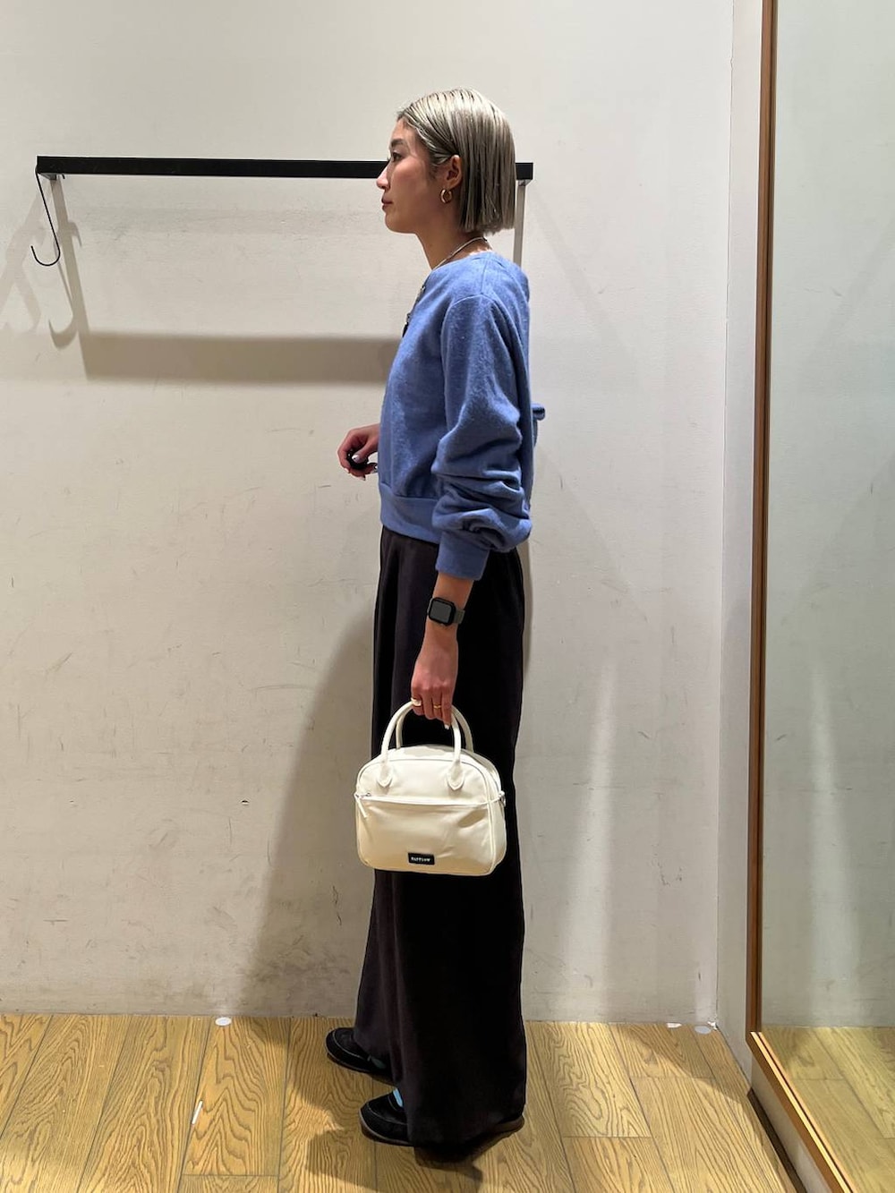 ホワイト系のハンドバッグ、ブルー系のTシャツ/カットソー、グレー系のその他パンツを着用したレディースの冬コーディネートの2枚目の写真