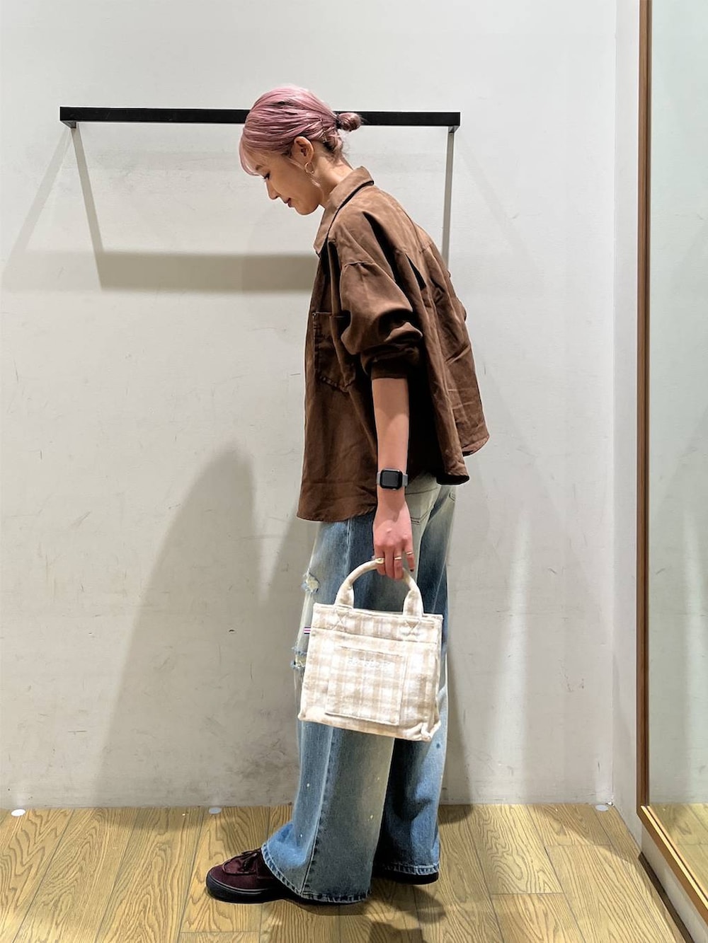 ブラウン系のシャツ/ブラウス、ベージュ系のトートバッグ、ブルー系のデニムパンツを着用したレディースの秋コーディネートの3枚目の写真