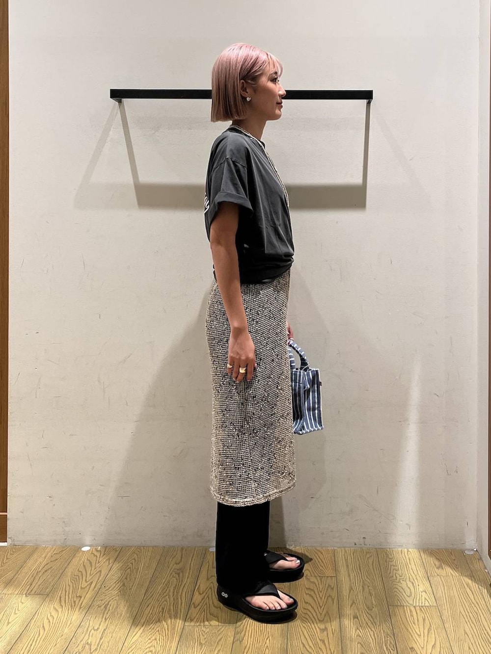 ブルー系のトートバッグ、ブラック系のサンダル、ベージュ系のワンピースを着用したレディースの夏コーディネートの2枚目の写真