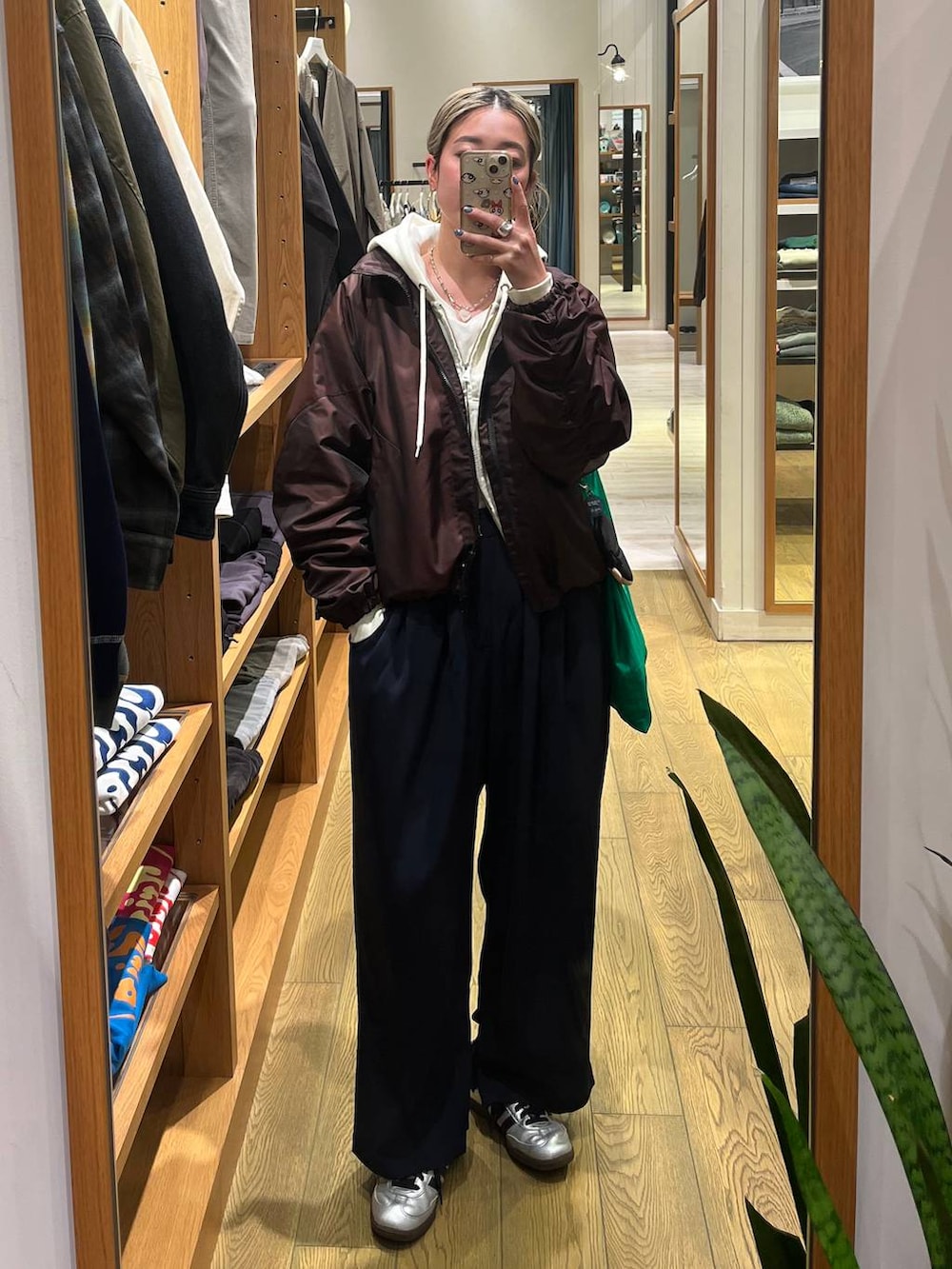 ブラウン系のブルゾン、ブルー系のその他パンツ、ベージュ系のパーカーを着用したレディースの春コーディネートの3枚目の写真